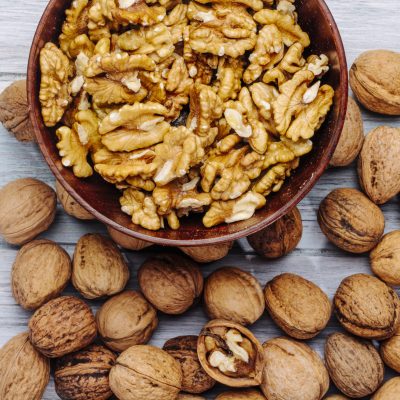 top view of walnuts in a bowl on rustic background